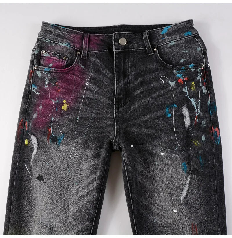 Close-up front view of Nofacebaby M33 Jeans with paint and rip details.