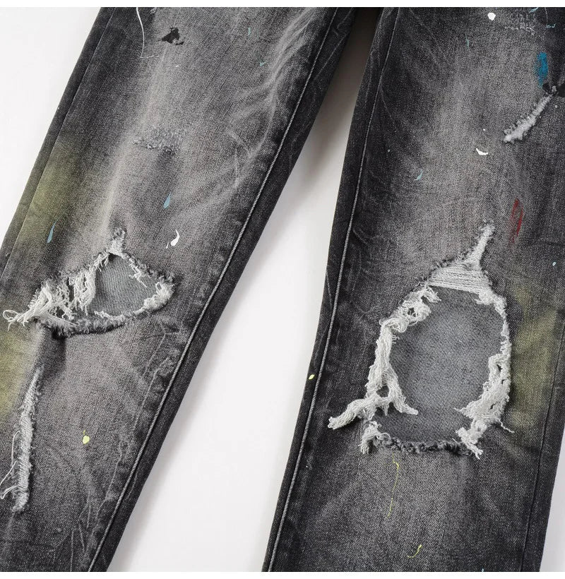Knee rip details on Nofacebaby M33 Jeans with paint splatters.
