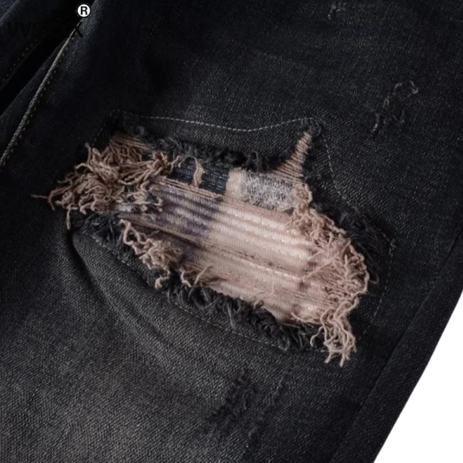 Detail of the Nofacebaby B13 jeans showing the knee area, with a close-up on the ripped accents and checkered fabric beneath, embodying the jeans' skinny relax fit.