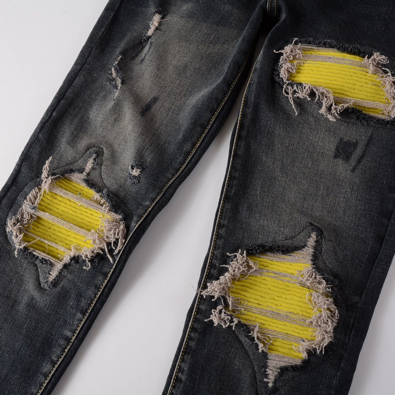 Detailed view of distressed areas with yellow patches on S7 Jeans.